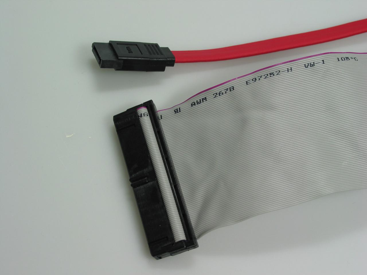 [07/02/2003] Kabel: SATA-Kabel (rechts) sind deutlich schmaler und flexibler als herkömmliche IDE-Kabel. Bei SATA fehlt zudem die Master-Slave-Unterteilung am Kabel.