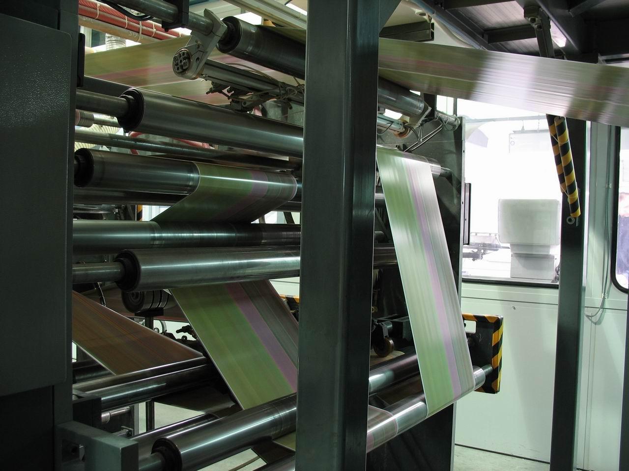 [09/07/2009] Druckmaschine: Im Falzapparat wird die bedruckte Papierbahn längsgeschnitten über Umlenkstangen (mehrfach) übereinandergelegt, im Trichter längs und in den Falzklappen quer gefalzt. 