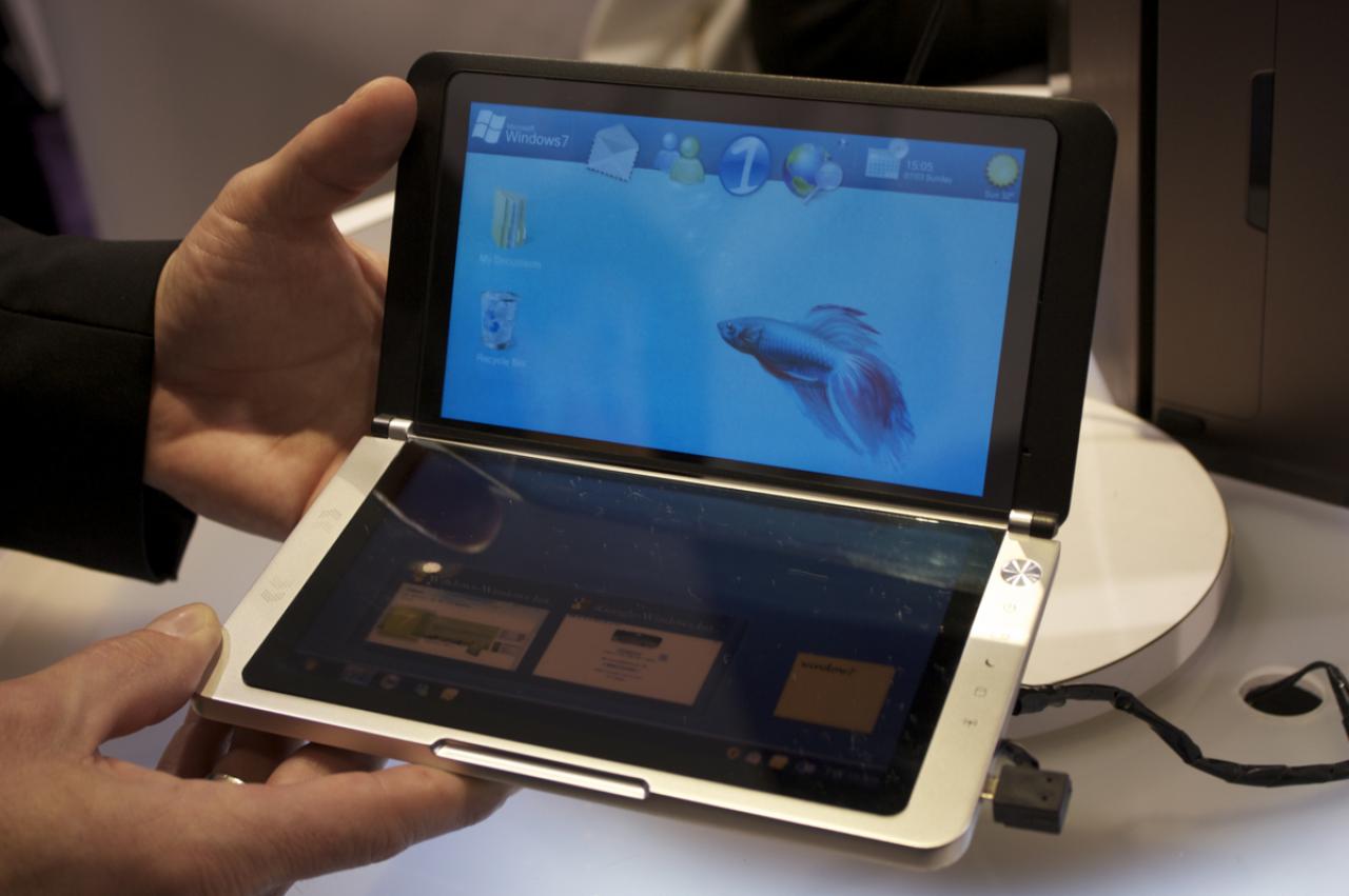 [08/01/2010] Die zwei Touchscreens dieses Winzlings messen gerade mal sieben Zoll. Das unter Linux laufende System ist mit einer ARM-CPU ausgestattet. Moment, Linux? Im Bild ist doch ein Windows-7-Logo zu sehen. Des Rätsels Lösung: Es handelt sich hierbei um ein Mock-up der Bildschirme - selbst ohne Akku würde Windows 7 stolz seine Anwesenheit verkünden. Cool: Der Deckel verrät dank eines speziellen Displays Infos wie die Zeit, den Ladestatus der Batterie sowie die WiFi-Empfangsstärke. (4)