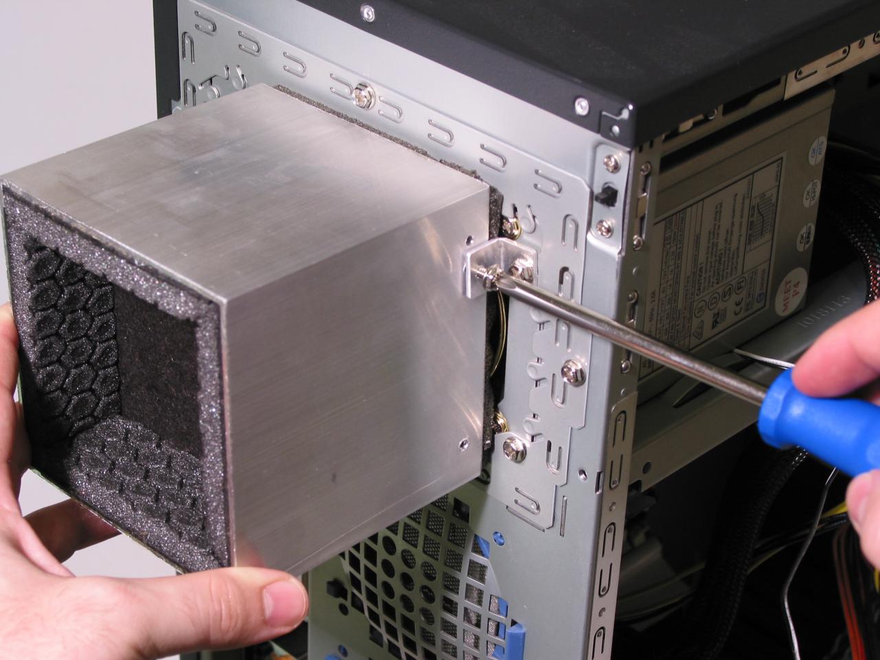 [21/04/2011] Meilensteine: Netzteil-Schalldämmung anno 2004: Die MR Box NT/80wird mit zwei Winkeln hinten an das PC-Gehäuse geschraubt. Die Abluft wird dann durch die Box geführt.