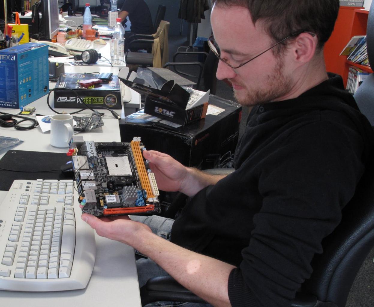 [23/09/2011] Daniel hält ein kleines Mainboard von Zotac in den Händen: Das A75-ITX Wifi im Mini-ITX-Format eignet sich für AMDs neuen Llano-Prozessor.