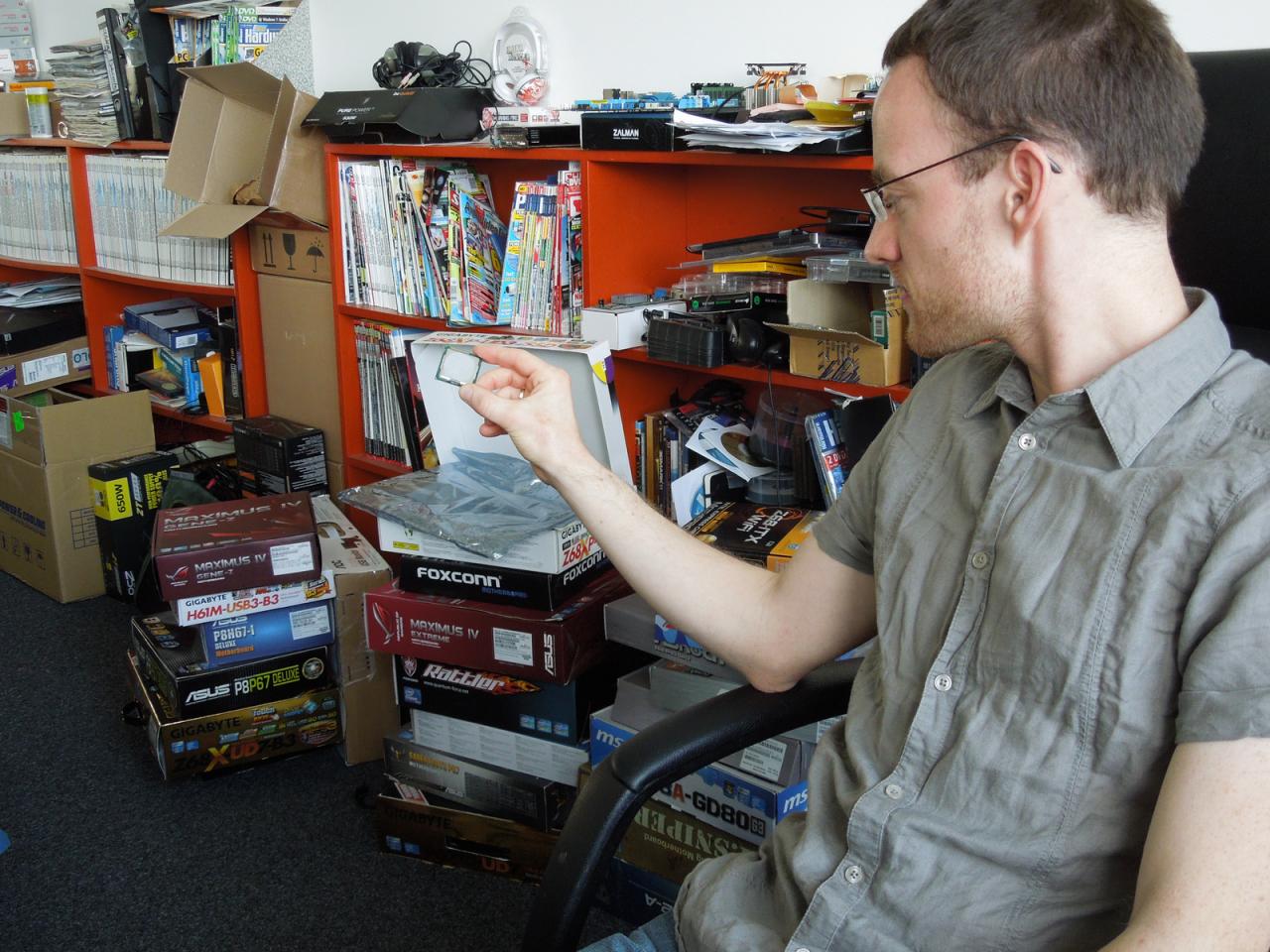 [11/05/2012] Die Ivy-Brigde-CPU die Kollege Möllendorf in der Hand hält, passt auf jede der im Hintergrund aufgestapelten Platinen. Welches Board dabei für Spieler mit schmalem Geldbeutel geeignet ist, hat Daniel bis zur Artikelabgabe mit Sicherheit herausgefunden. 