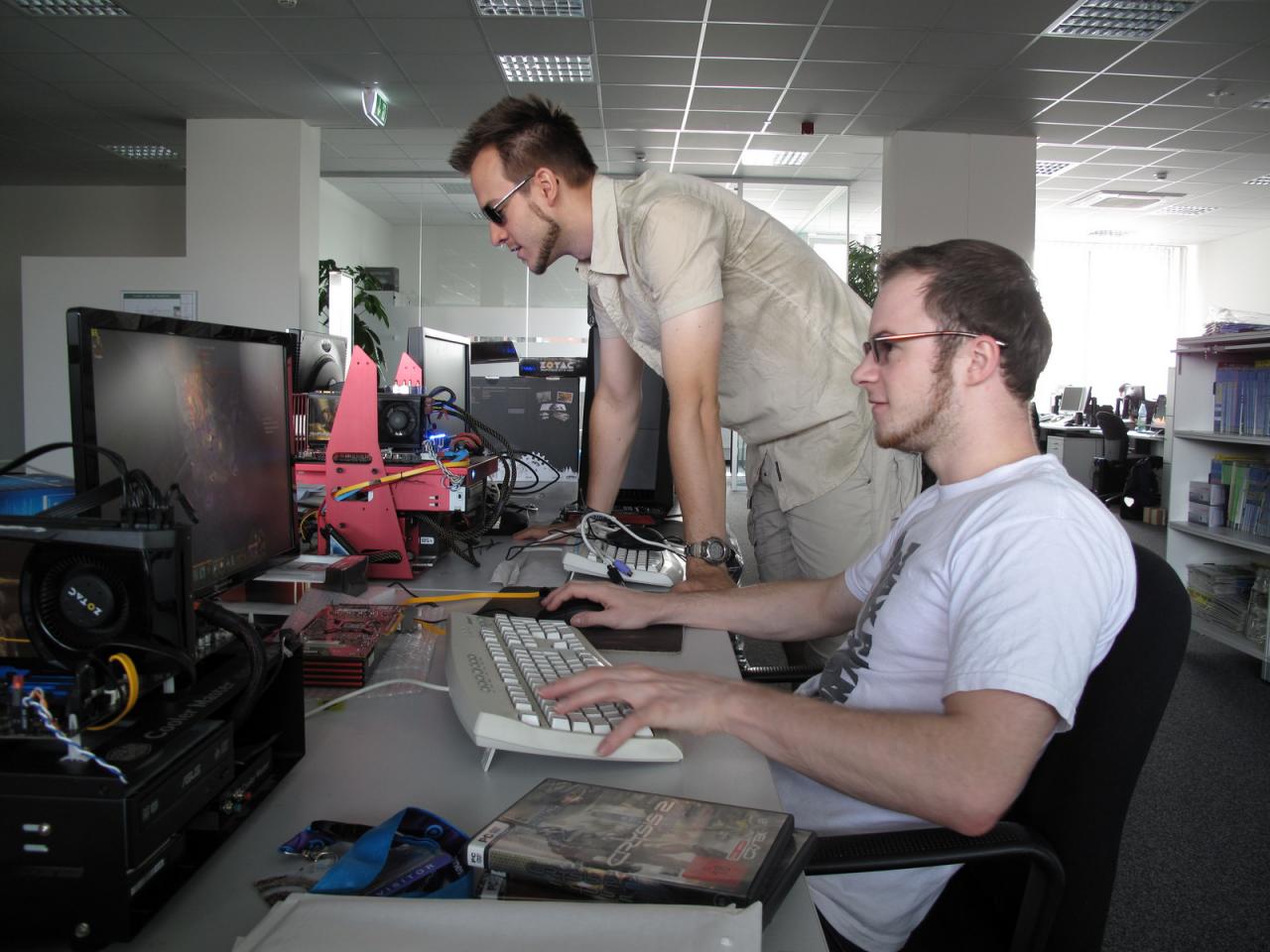 [24/08/2012] Unser dynamisches Duo bei der Arbeit. Beachten Sie die äußerst sinnvolle Arbeitsaufteilung, Während der Benchmark zockt, macht der Raff schlaue Sprüche, oder so. Und bei der Wahl der Sehhilfe und dem Bartschnitt scheinen sich die beiden auch abgesprochen zu haben. 