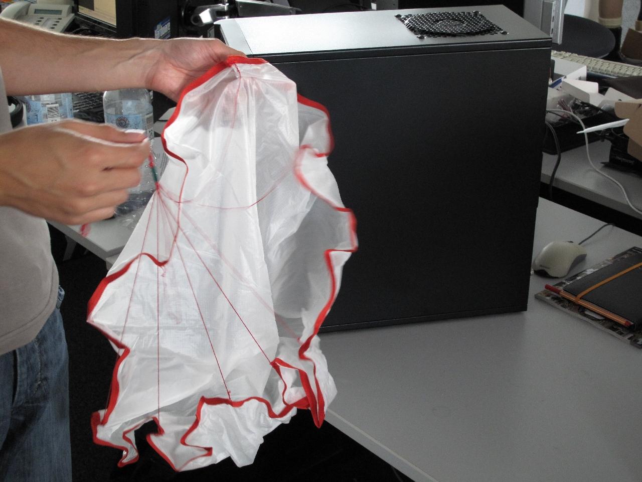 [17/08/2012] Daniel Waadt präsentiert den wundervollen Fallschirm, der die Hardware am Wetterballon sicher zur Erde bringen soll. Im Hintergrund können Sie bereits einen Blick auf den brandneuen PCGH-PC mit einer Geforce GTX 660 Ti werfen. Übrigens kam diese Woche auch ein ferngesteuertes Auto an. Dieses wird im nächsten PCGH in Gefahr Video eine bedeutende Rolle spielen.