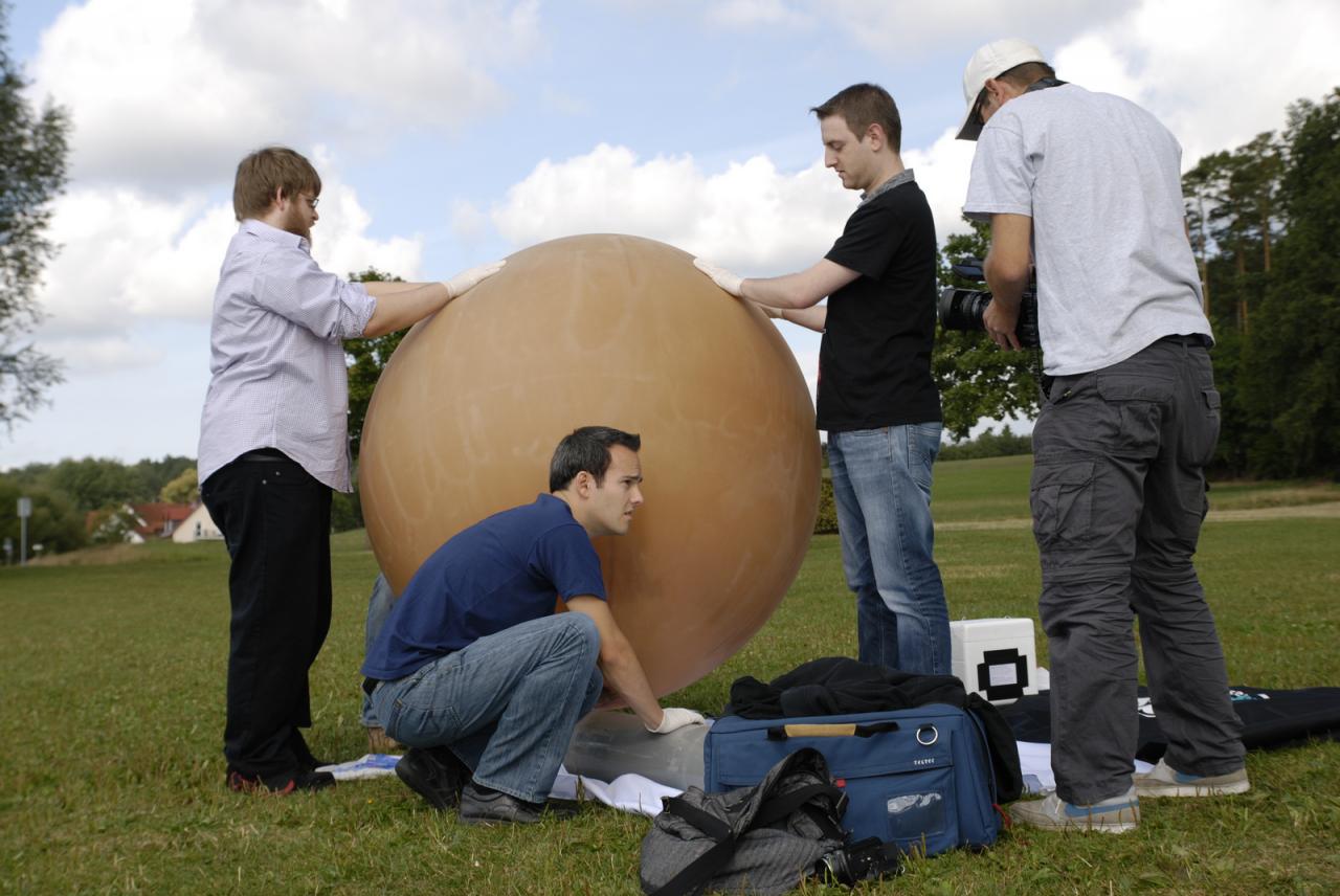 [07/09/2012] Nein, eine ruhige Kugel schieben die Herren Wilke, Staudacher und Waadt hier nicht. Das ist der mit einer HDHERO2- sowie iPhone-Kamera ausgestattete PCGH-Wetterballon kurz vor seinem Start in den Weltraum - zumindest fast, denn die tatsächliche Flughöhe betrug ca. 33 Kilometer. Entgegen Reinhards Wünschen landete das Teil aber nicht in den Bergen Tirols. 