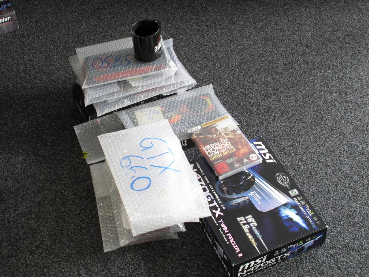 [26/10/2012] Da Herr Vötter sich scheute noch einmal persönlich abgelichtet zu werden, hat er uns hier nur einen Grafikkarten-Stapel hinterlassen - natürlich nicht ohne seine geliebte 3Dfx-Tasse (mal wieder) zur Schau zu stellen. Ach ja und mit der MoH Warfighter-Version will er natürlich zeigen, dass er trotz Produktionsende schon wieder fleißig spielt - äääh, Benchmarks anfertigt. ;-)