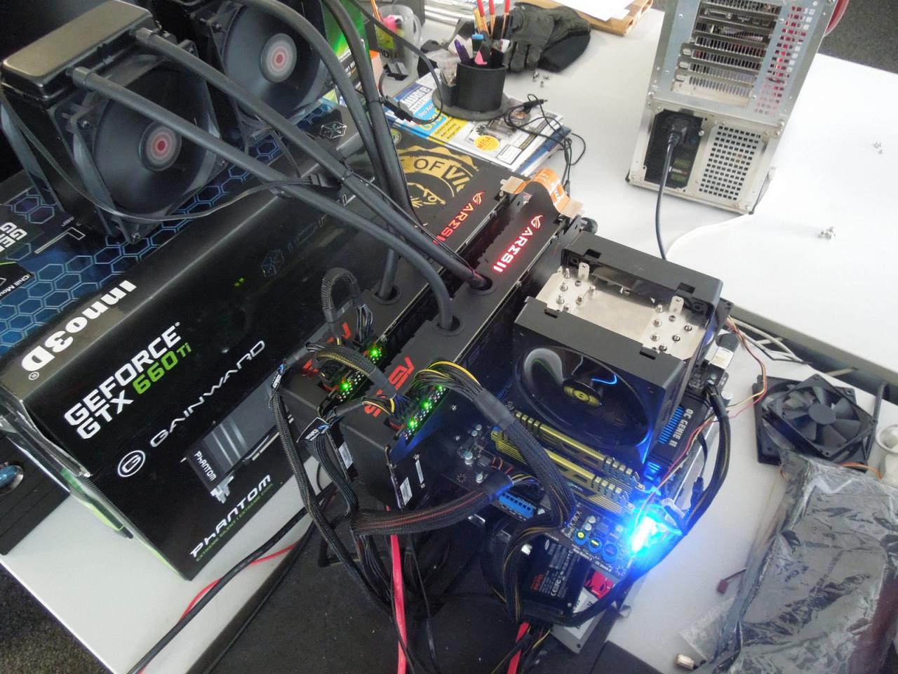 [08/02/2013] Asus Ares 2 in Aktion. Obwohl Raff noch befürchtet hatte, dass ein 1000-Watt-Netzteil für die vierfache HD-7970-Render-Power nicht reicht, lief der Testaufbau zumindest ohne Overclocking problemlos. Und erfindungsreich ist der Herr Vötter auch noch, das beweist die ungewöhnliche aber durchaus funktionale Halterung der Radiatoren für die beiden Grafikboliden. 