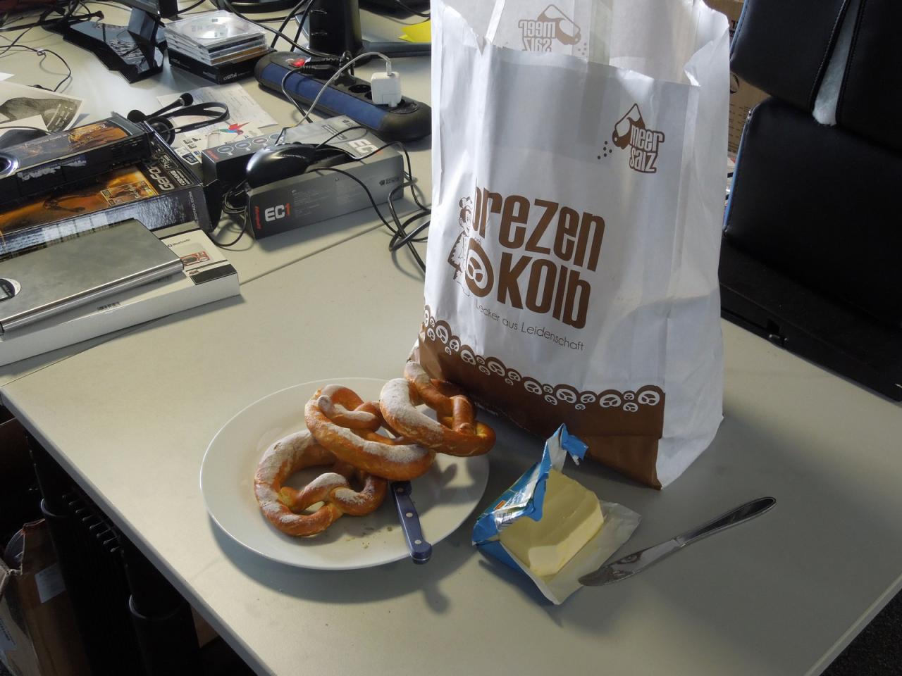 [22/03/2013] Unser Meister ist wieder ein Jahr älter, äh weiser geworden und hat uns frische Brezeln der Nürnberger Traditionsbäckerei Kolb zum Frühstück spendiert - Cheffe weiß halt, wie er die Truppe an hektischen Abgabetagen motiviert. Wie alt Herr Bayer geworden ist, wollen Sie wissen? Sagen wir es mal so, unser Redaktionsoldie Frank ist nur ein Jahr älter, aber ist wie Thilo schon vier Dekaden auf der Welt.