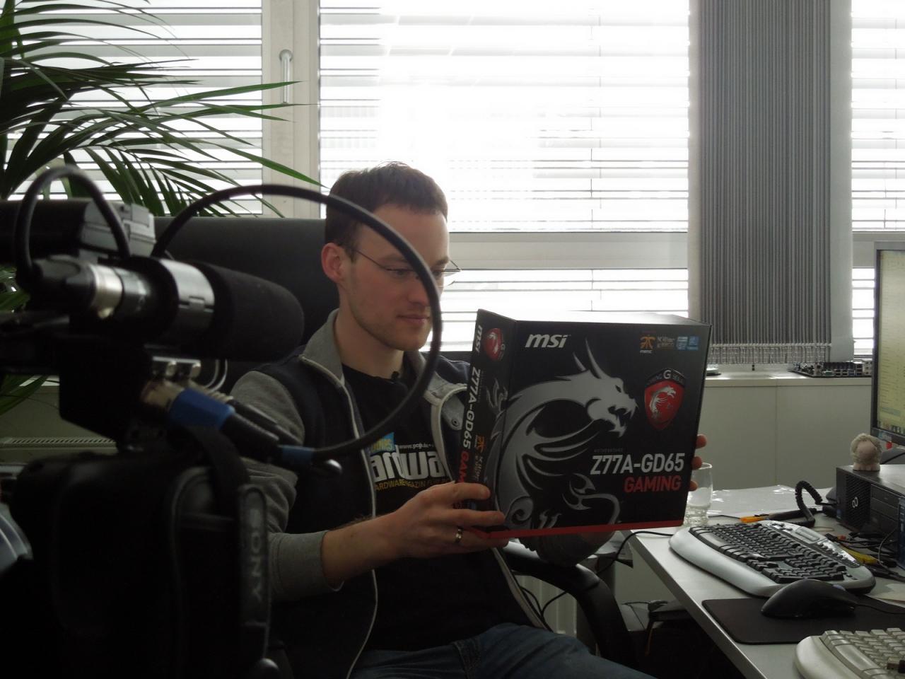 [12/04/2013] Auch unser Daniel kommt nicht darum herum vor der Linse sein Fachwissen zum Besten zu geben. Fast schaut es so aus, als hätte er die Kamera gar nicht bemerkt, zumindest scheint er ganz andächtig die Spezifikationen der neuen MSI-Z77A-GD65-Platine zu studieren. Ach Daniel, tu doch nicht so, als alter Mainboard-Experte kennst du die sogenannten Specs doch schon längst auswendig.