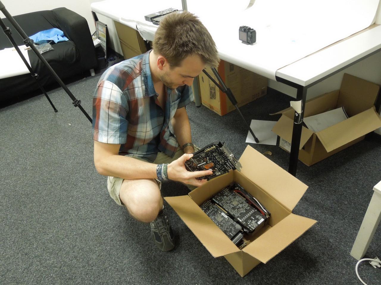 [26/07/2013] Raff hat einen in der Kiste - stimmt nicht, denn er hat ganz viele GTX-760-Grafikkarten für ihren Fototermin in einen Karton gepackt. Und irgendwie scheint Herrn Vötter seine Testmuster zu mögen, denn er wirkt schön etwas so als würde er jede einzelne noch einmal ganz fasziniert anschauen und putzen, bevor sie zum Ablichten auf dem Fototisch platzierte werden.
