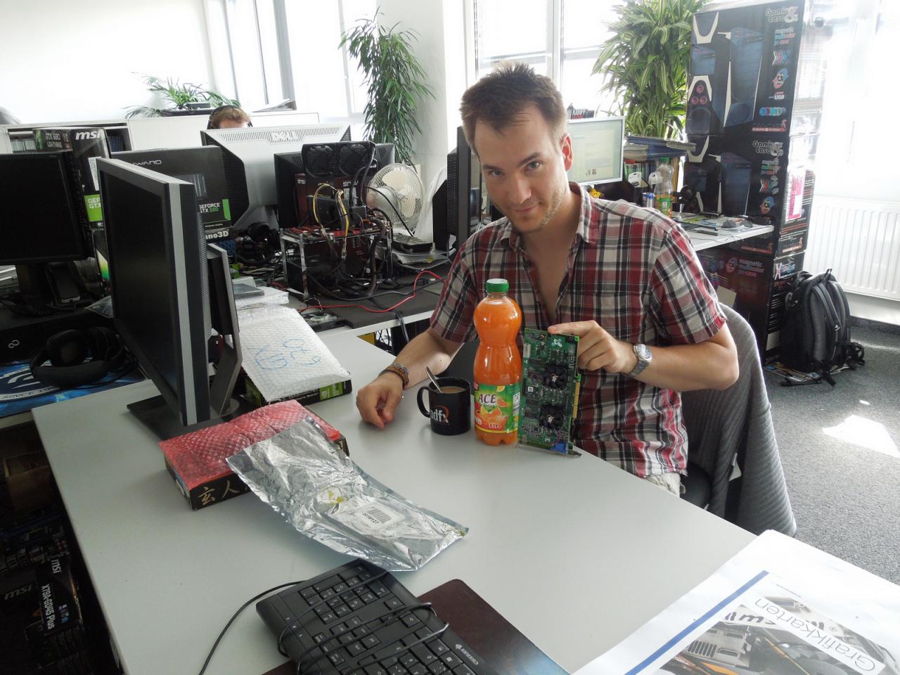 [27/09/2013] Wie dieses Bild mal wieder eindrucksvoll beweist stehen Devotionalien bei unserem Grafik-Guru Raff hoch im Kurs. Ok, die riesige Flasche mit Vitaminsaft sollte er zu Alibi-Zwecken auf seinen Schreibtisch stellen, aber die anderen Kleinodien präsentiert Herr Vötter immer wieder gerne. Mit Sicherheit wissen Sie spätestens jetzt, was unser Raff da für eine Grafikkarte in der Hand hält, oder?
