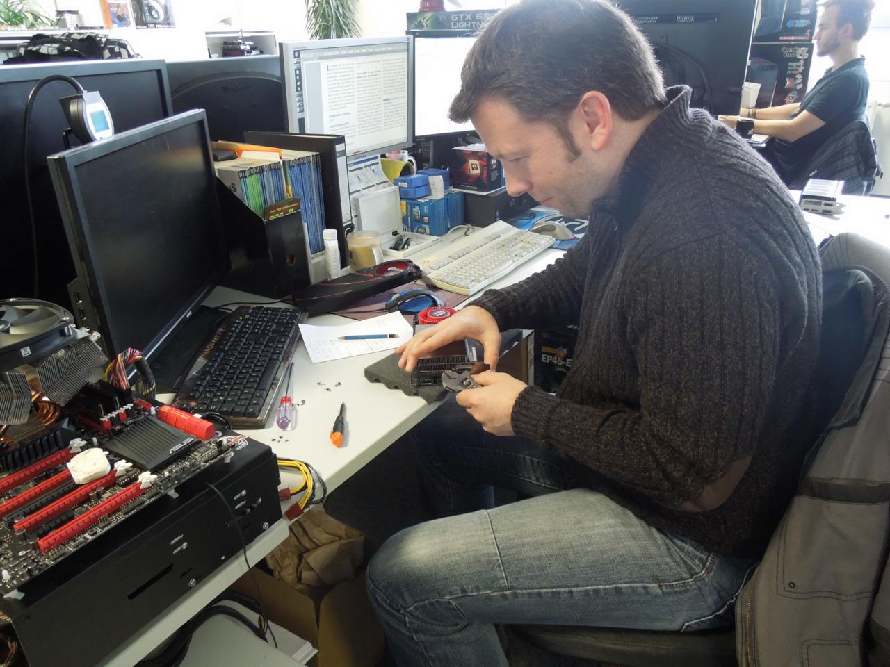 [22/11/2013] Doktor Spille darf, und das macht es ja besonders gerne, wieder basteln. Nur dieses Mal entfernt er nicht etwa den Kühler seiner eigenen Radeon-Karte, der bleibt da schön drauf. Er hilft seinem gestressten Kollegen, der am Abgabefreitag um 15:00 seine Grafikkarten-Megatests immer noch nicht fertig hat. Und wie Sie sehen ist unser Carsten trotz des gewaltigen Zeitdrucks die Ruhe in Persona - verständlich, denn nur so gelingt der Umbau.