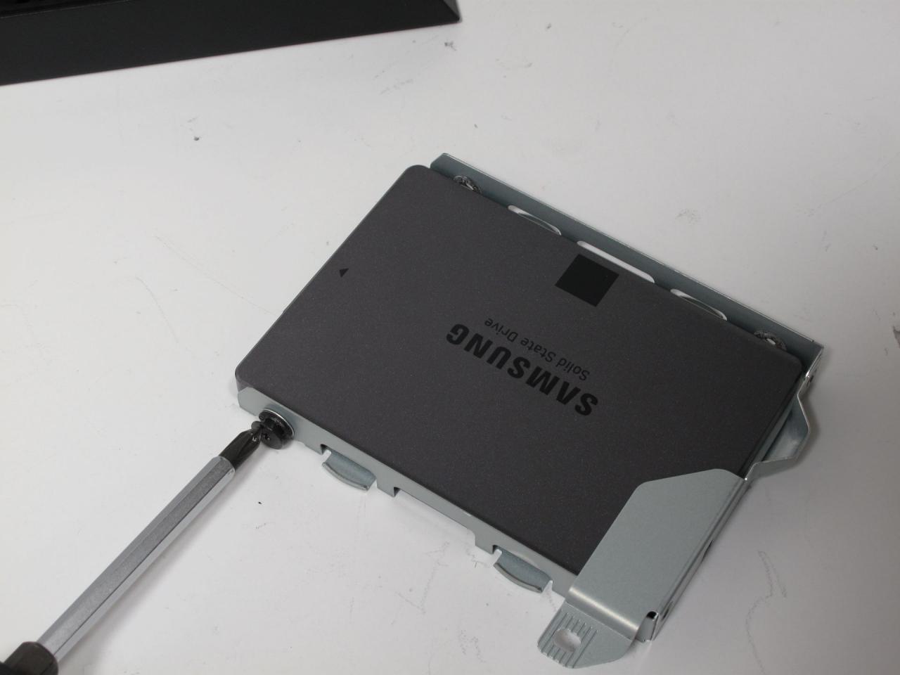[21/11/2013] Sobald erledigt, lässt sich die Festplatte entfernen. Schrauben Sie nun die SSD fest. Die Anschlüsse gehören auf die dem Haltegriff entgegengesetzte Seite.