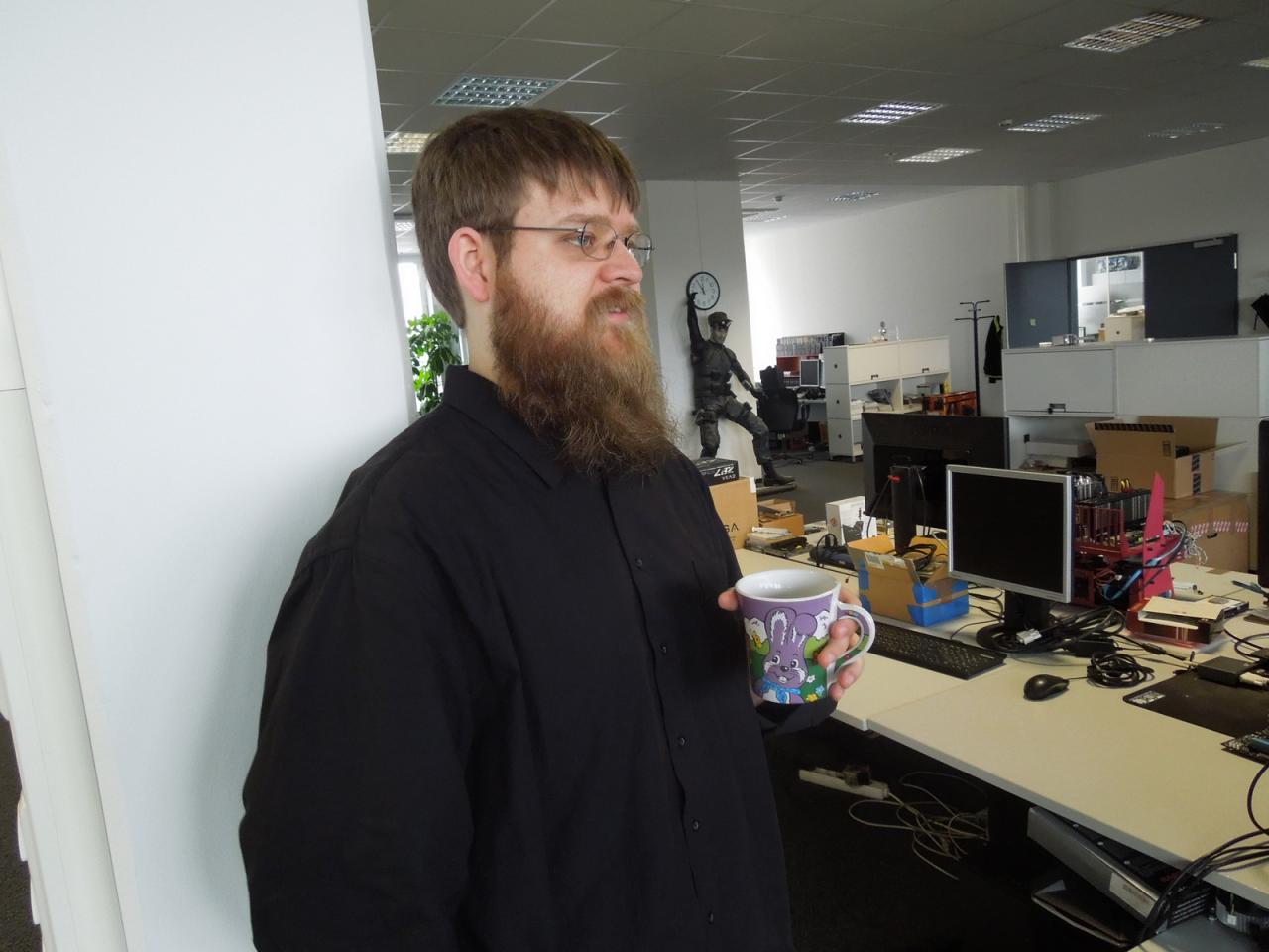 [28/05/2014] Stephan, sonst eher als unauffälliger und gutmütiger Forumsleiter bekannt, will mit dem diesem Bild einmal einen Kontrapunkt zu der schon fast inflationär gezeigten 3Dfx-Tasse setzen. Während der Redakteur mit dem immer länger werdenden Rauschebart gerade ein Fachgespräch mit Doktor Spille führt, hält er ganz provokativ seine Osterhasen-Tasse in die Kamera. Und meinen Sie nicht auch, dass die viel schöner als Raffs Kleinod ausschaut?