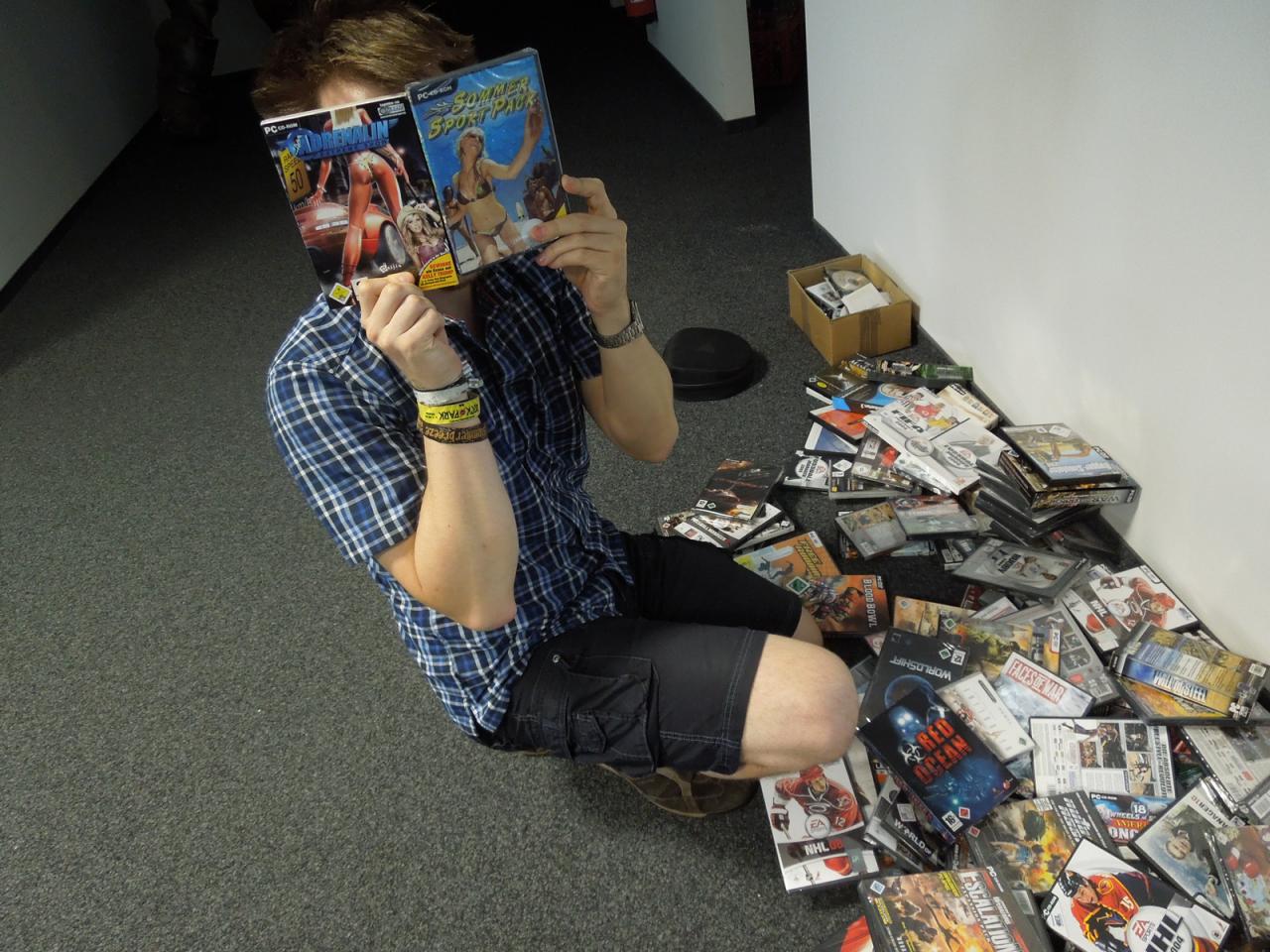 [01/08/2014] Welch ganz besonders brisante Spiele-Highlights unser Archiv auf Lager hatte, demonstriert dieser Herr im Bild eindrucksvoll. Leider hat er nicht bedacht, dass es mit der Anonymität wohl nicht zum besten steht, denn von der Kleidung abgesehen verrät ihn auch die markante Frisur. Die ist nämlich teils noch hinter den Spielehüllen zu sehen, welche leicht bekleidete Damen sowie eine nette weibliche Hinteransicht zieren, oder, Raff, hehe. ;-)