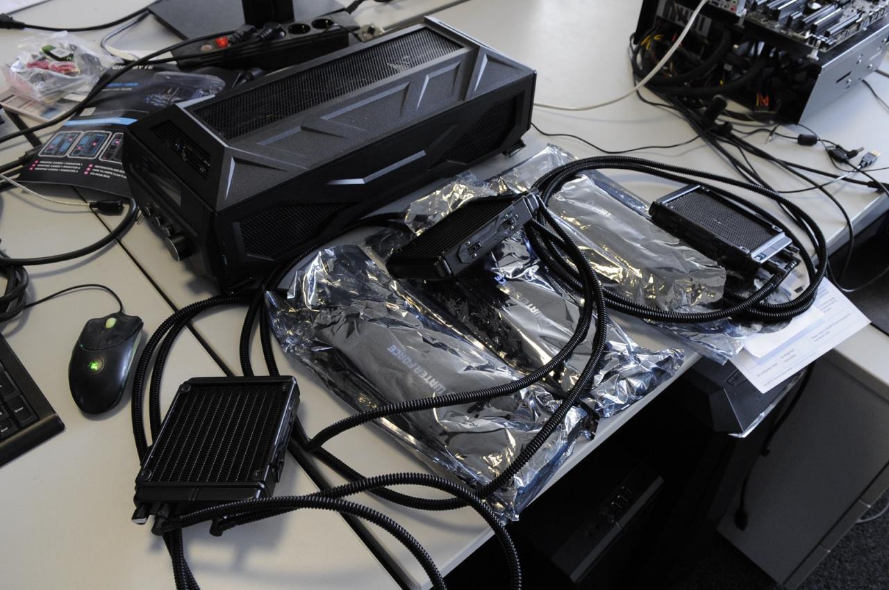 [10/04/2015] ... gleich drei GTX-980-Karten gehören! Jetzt erklärt sich auch, dass so eine exklusive Kombi nicht nur ein einem schnöden Pappkarton, sondern in einem speziellen Trolley geliefert wird. Noch liegt das edle Triple zu Showzwecken auf dem Arbeitsplatz neben Urlauber Carsten. Doch spätestens Montag ist der wieder da und wird unseren Schlumpf Loske schon antreiben, die Edelhardware in ein passendes Gehäuse einzubauen.