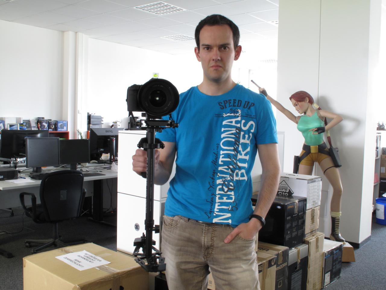 [13/05/2015] Unser E-Commerce-Spezialist Daniel wollte unseren Bilder-der-Woche-Fotografen mal richtig beeindrucken. Zu diesem Zweck hat Herr Dr. Waadt sein privates Kamera-Equipment mit in die Redaktion gebracht, damit der Spieleonkel mal richtig neidisch wird. Und das ist er zugegebenermaßen auch geworden! Das digitale Spiegelreflex-Moped mit seinem riesigen Objektiv hat ihm auch gefallen, doch für noch mehr Begeisterung und Neid sorgte das Spezialstativ. Damit könnte man noch viel mehr und noch spontanere Schnappschüsse vom Redaktionsalltag machen.