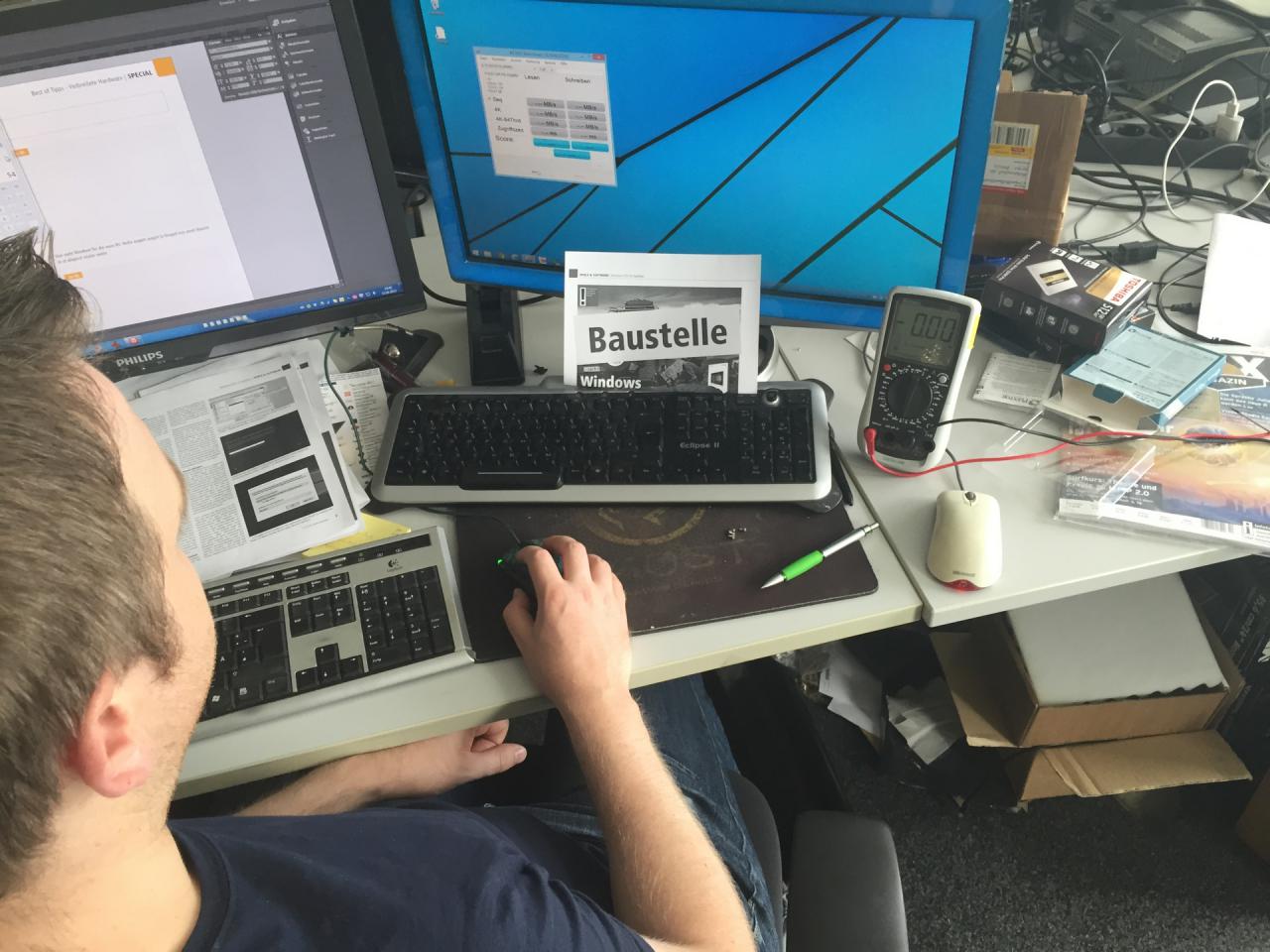 [04/09/2015] Reinhard, unser Schreiber aus Südtirol, ist ja bei uns mittlerweile die Kompetenz, wenn es um Windows 10 geht. Obwohl Don Stone hier auf dem Bild ausnahmsweise mal wieder SSDs testet, ist das Thema bei Herrn Staudacher immer präsent und das improvisierte Schild hinter seiner Tastatur könnte durchaus als Steinharts-Windows-10- Statement gelten. Damit er allerdings jetzt keinen Ärger mit Microsoft bekommt, gestehen wir, dass es sich bei dem ominösen Schild um einen Ausdruck eines Artikelaufmachers für die kommende PCGH 11/2015 handelt.