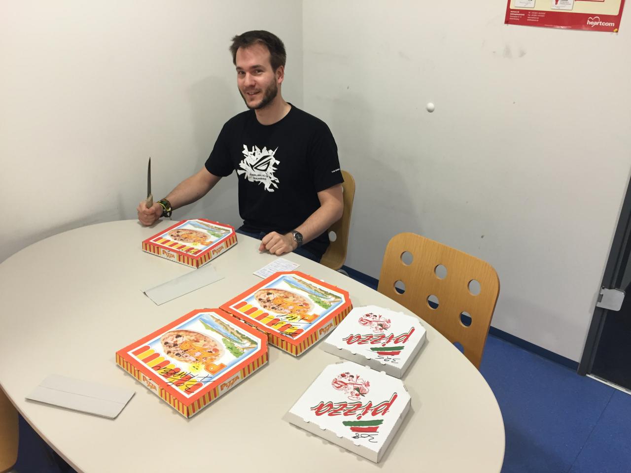 [15/01/2016] Dass unser Kantenglättungskönig ein hungriges Kerlchen ist und im Falle von Pizza auch mal mehr als ein Exemplar konsumiert, ist zwar erwähnenswert, aber bestimmt nicht sonderlich interessant. Sie fragen sich bestimmt eher, warum der Grafik-Guru ganz alleine in der Küche sitzt und sein Mittagsmahl einnimmt. Hat er etwa den Rest der Belegschaft mit der schon fast überdimensionierten Ansichtskarte aus Solingen verscheucht, um ungestört der Völlerei zu frönen? Oder wollen die Kollegen nicht mit ihm speisen, weil der ihnen zu viele Seiten im Wochenplan auf's Auge gedrückt hat? Beides ist Blödsinn, Raff war einfach nur der erste, der mitbekommen hat, dass die Pizza schon geliefert wurde. Jetzt wird's aber Zeit, den Rest der Truppe zu informieren.