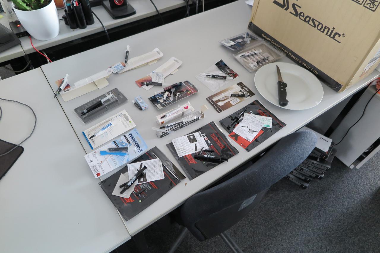 [24/03/2016] Als wir Ihnen vor einigen Wochen Stephans Musterbestand für den Wärmeleitpasten-Test präsentierten, waren sie noch verschweißt in der Verpackung zu finden. Wie Sie sehen können, sind die Arbeiten am Artikel inzwischen fortgeschritten. Die Anzahl der auf dem Tisch liegenden Spritzen lässt es erahnen, wie Stephan die CPU im Akkord bepinseln muss.