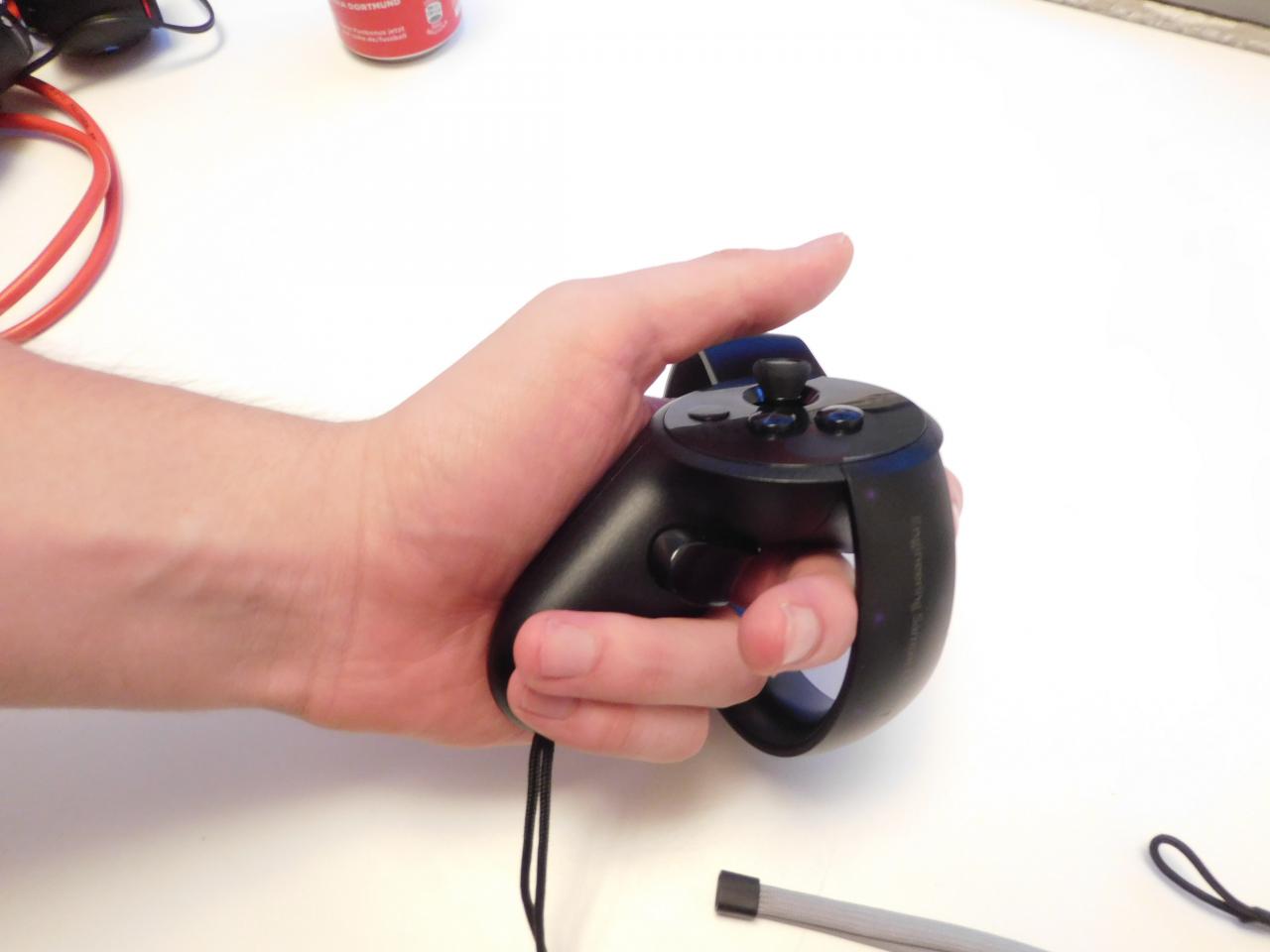 [28/09/2016] Der kleine Griff des Oculus Touch verschwindet in größeren Händen beinahe, lässt sich aber trotzdem entspannt halten und bietet bequemen Zugriff auf zwei Trigger und die Tasten auf der Oberseite.