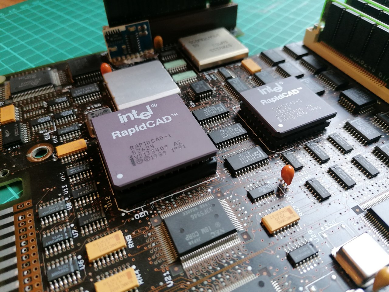[15/04/2022] Update vom 16.04.2022: CPU von das_bohnvirus - Dieses Mal zeigt z. B. das_bohnvirus einen Intel RapidCAD-1. Dabei handelt es sich um einen 486DX mit speziellem Package, der zusammen mit einem zweiten Chip, dem RapidCAD-2 als Aufrüstset angeboten wurde. Beim Intel 80386 übernahm die Fließkommaberechnungen noch der Extra-Chip 80387, der 486DX beinhaltete aber bereits eine Fließkommaeinheit. Daher ist der RapidCAD-2 lediglich ein Dummy, welcher aus Kompatibilitätsgründen (zur Erzeugung des FERR-Signals) in den ursprünglich für den Koprozessor für Fließkommaberechnungen vorgesehenen Sockel eingesetzt werden musste.