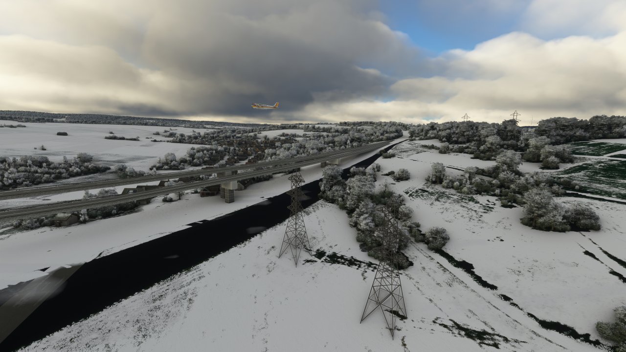 [23/01/2023] Microsoft Flight Simulator - Brücken stellen eine Herausforderung für den Flight Sim dar. Problematisch sind außerdem Schattenwürfe (teils auch die von Wolken), die während der Satellit- oder Fotoaufnahmen von der echten Sonne auf die Landschaft geworfen wurden. Hier sehen Sie einen doppelten Fail: Der Schatten der Brücke (und jener der Strommasten) ist in den Landschaftsaufnahmen enthalten, die Brücke ist zudem zweigeteilt respektive mehrstöckig und verschwindet im Nichts. Der virtuelle Verkehr fährt indes unter der eigentlichen Brücke. Dies kann sehr immersionsstörend sein. Im Bild: Die (Ahr-)Talbrücke der A61 bei Bengen.&nbsp;