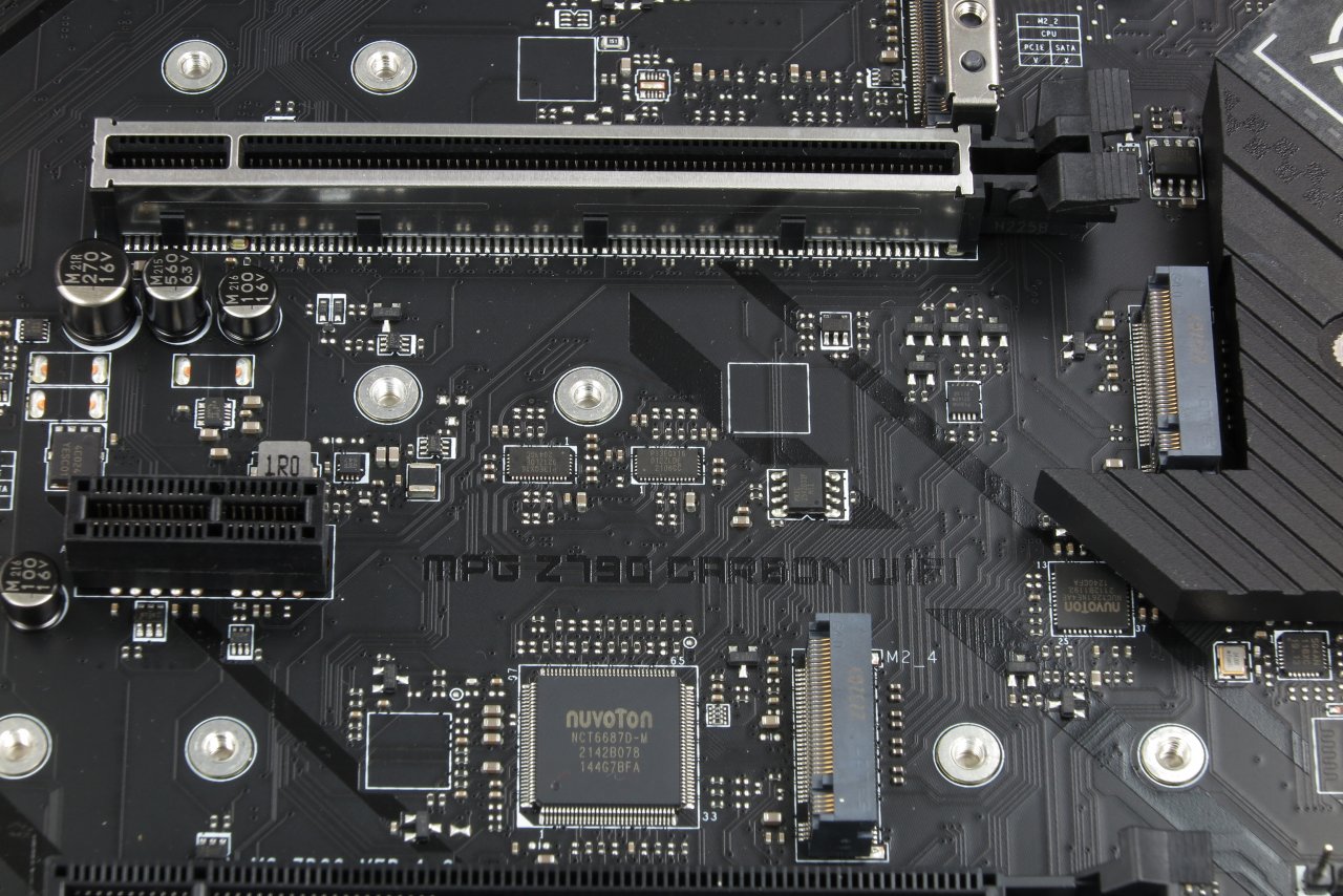 [13/03/2023] MSIs Z790 Carbon trägt Retimer (die beiden Bauteile im Zentrum des Bildes) sogar für die scheinbar kurze Strecke zwischen PCI-Express-4.0-×4-Slot und I/O-Hub. Für Teile der -5.0-Grafikkarten-Anbindung an die CPU finden sich weitere Verstärker-Bauteile auf der Platinen-Rückseite.