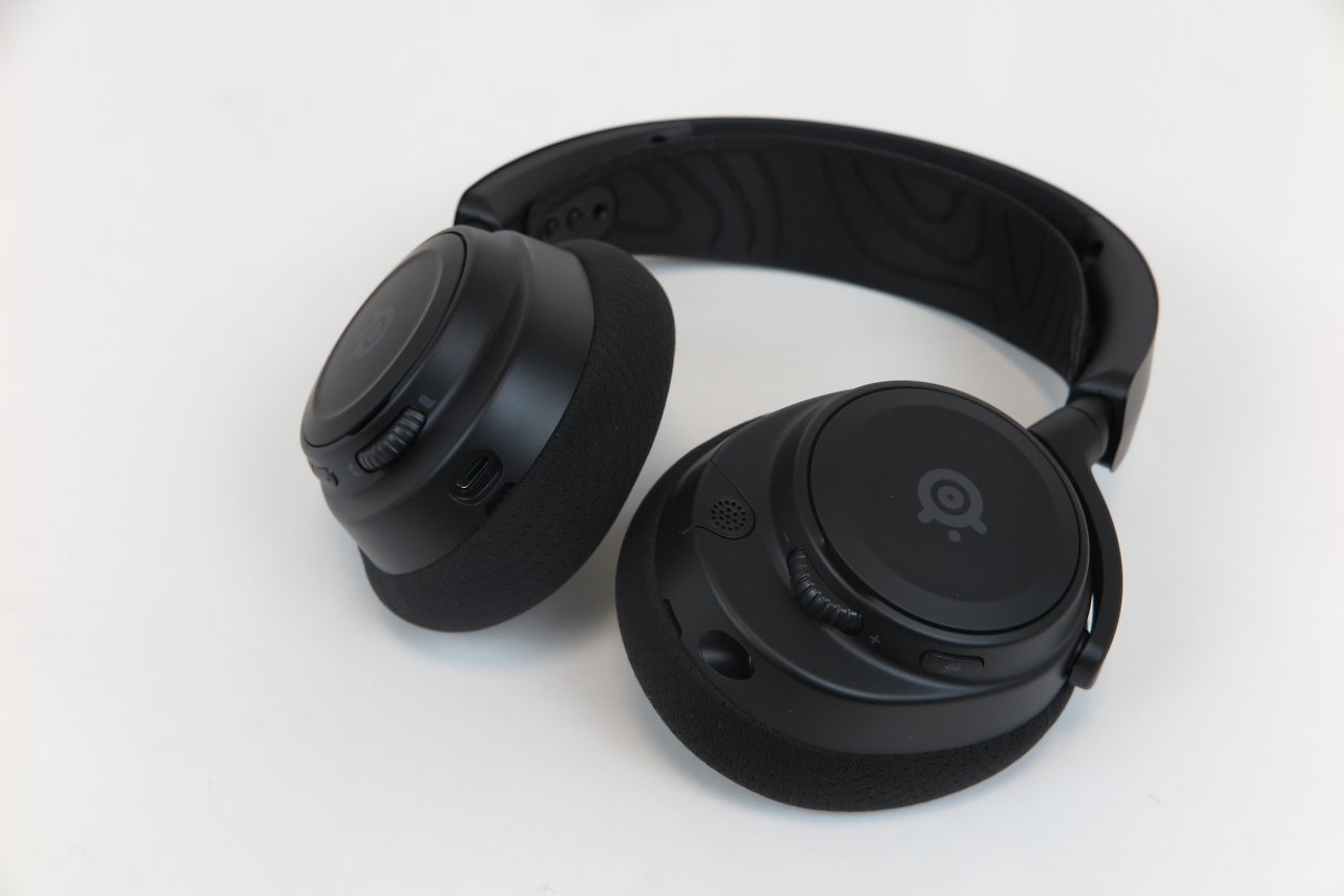 [10/07/2023] Steelseries Arctis Nova 7 – Die Oberklasse-Version der Nova-Reihe kommt mit Wireless Funk und optionalem Klinkenanschluss. Wieder stehen eine Reihe Features und gegenüber dem Nova 3 zudem einige weitere Funktionen hinzu.Die Treiber sind weiterhin die gleichen wie in Actis Nova 1P und Nova 3, allerdings ist die Abstimmung ein wenig anders. Neben den Anschlüssen unterscheidet sich das Nova 7 indes vor allem äußerlich, denn es nutzt das Design - inklusive Aluminium-Bügel und weiteren Details - des Topmodells Nova Pro und bietet eine nochmals höhere Qualitätsanmutung als die kleineren Geschwister. Auf Extra-Flair, etwa in Form von gebürsteten Seitendeckeln und weitere Akzente des Top-Modells verzichtet das Nova 7 allerdings.