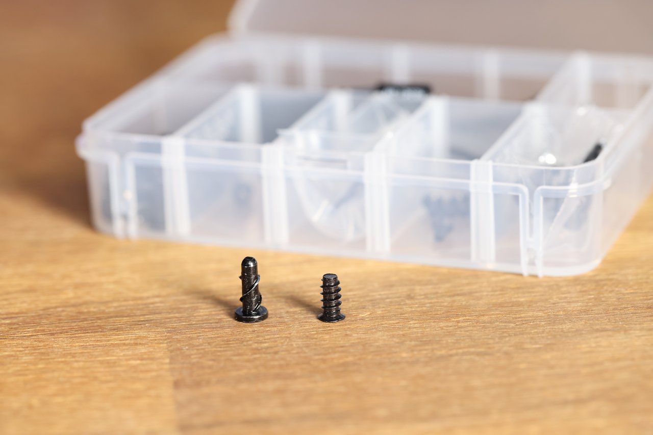 Kurios: Obwohl das Corsair 6500X keine Lüfter mitliefert, sind alternative an der Spitze weichere Lüfterschrauben mit anderem Gewinde-Konzept in der Schraubenbox enthalten (links). Im Vergleich zu den üblichen Fan-Screws (rechts) fallen diese länger und beim Reinschrauben erst etwas schwerer, dann leichtgängiger aus.&nbsp;