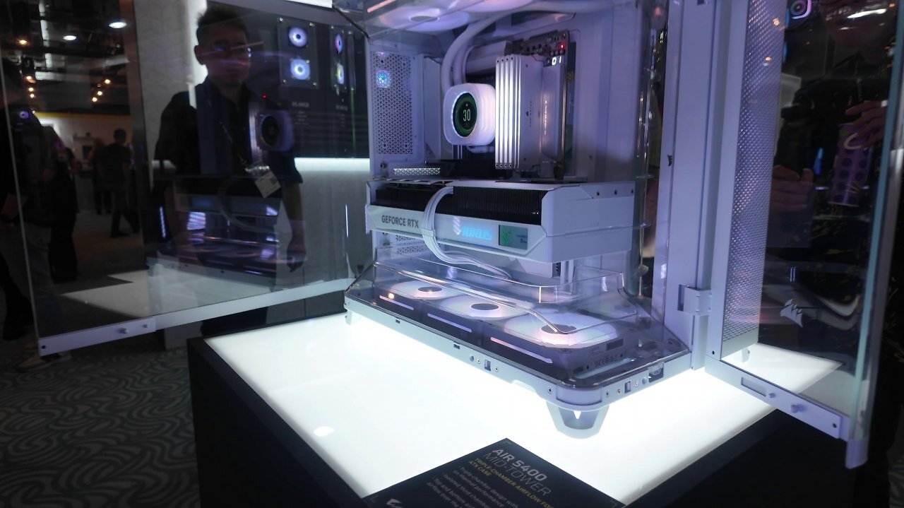 [03/06/2025] Auf der Computex 2025: Zu Besuch bei Corsair. Das Air 5400 ist vor allem für 360-mm-Kompaktwasserkühlungen prädestiniert. Sowohl am Heck als auch an der Front ist das Glas abgerundet. An der Unter- und (da eher dekorativ der) Oberseite befinden sich transparente Luftführungstunnel. Als Drei-Kammer-Gehäuse sind AiO-Kühlungen an der rechten Seite komplett abseits der Innenkammer mit Temperaturvorteil.