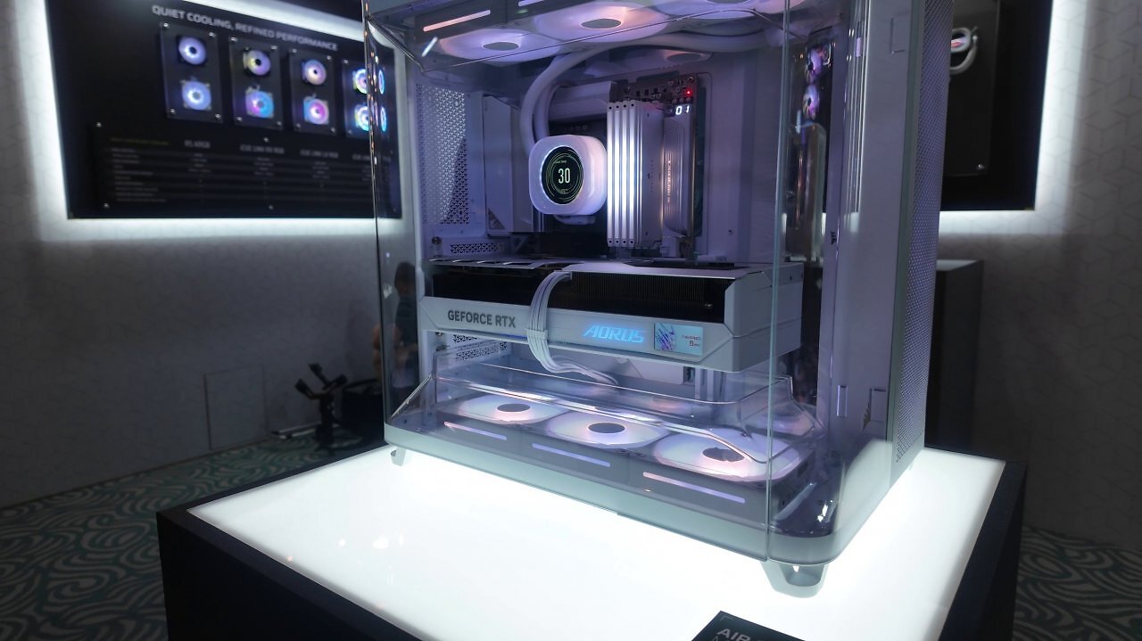 [03/06/2025] Auf der Computex 2025: Zu Besuch bei Corsair. Das Air 5400 ist vor allem für 360-mm-Kompaktwasserkühlungen prädestiniert. Sowohl am Heck als auch an der Front ist das Glas abgerundet. An der Unter- und (da eher dekorativ der) Oberseite befinden sich transparente Luftführungstunnel. Als Drei-Kammer-Gehäuse sind AiO-Kühlungen an der rechten Seite komplett abseits der Innenkammer mit Temperaturvorteil.