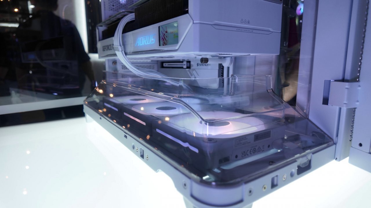 [03/06/2025] Auf der Computex 2025: Zu Besuch bei Corsair. Das Air 5400 ist vor allem für 360-mm-Kompaktwasserkühlungen prädestiniert. Sowohl am Heck als auch an der Front ist das Glas abgerundet. An der Unter- und (da eher dekorativ der) Oberseite befinden sich transparente Luftführungstunnel. Als Drei-Kammer-Gehäuse sind AiO-Kühlungen an der rechten Seite komplett abseits der Innenkammer mit Temperaturvorteil.