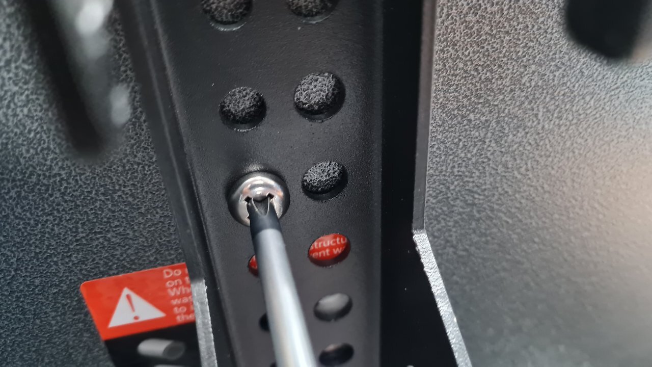 Ein Schraubenzieher dreht eine Schraube in ein Metallteil