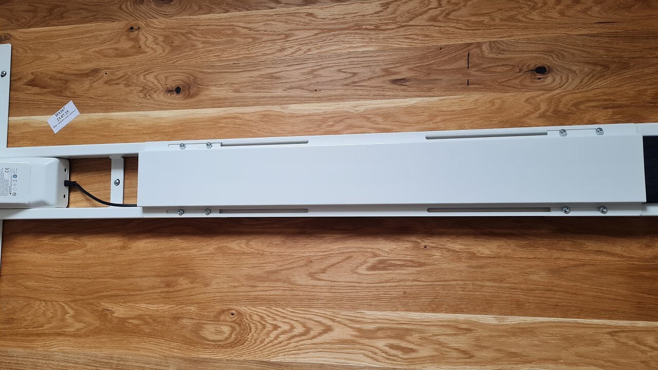 Die Unterseite eines höhenverstellbaren Schreibtischs mit Steuerbox und Kabeln.