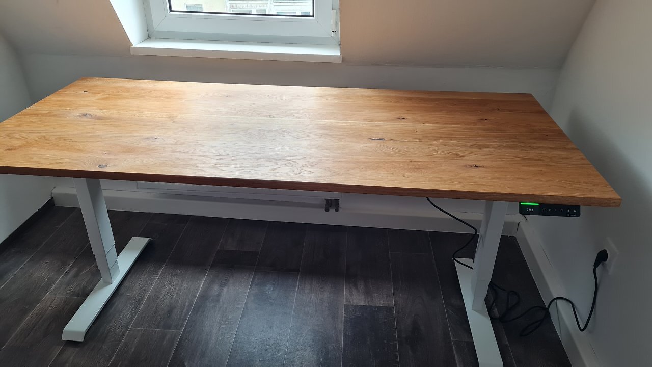 Ein höhenverstellbarer Schreibtisch unter einer Dachschräge.