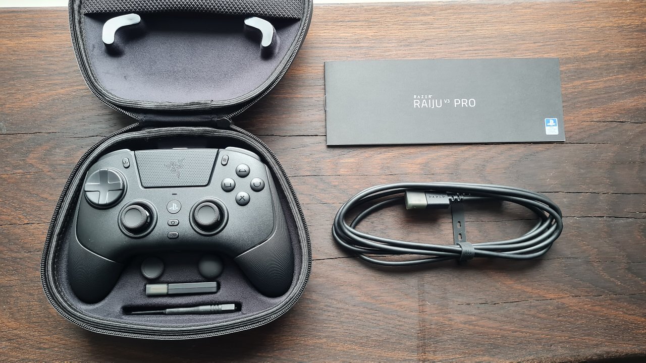 Ein schwarzer Controller mit Zubehör auf einem Holztisch.