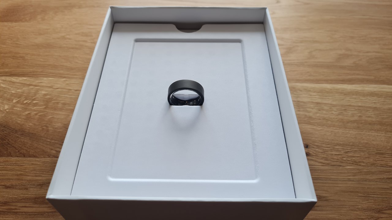 Ein Smart Ring liegt in seiner Packung auf einem Holztisch