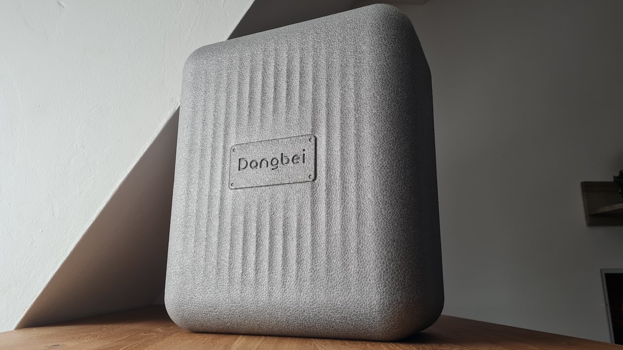 Ein großer, grauer Koffer auf einem Holztisch