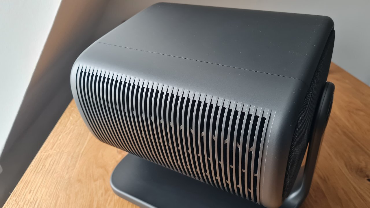 Ein grauer Beamer auf einem Holztisch