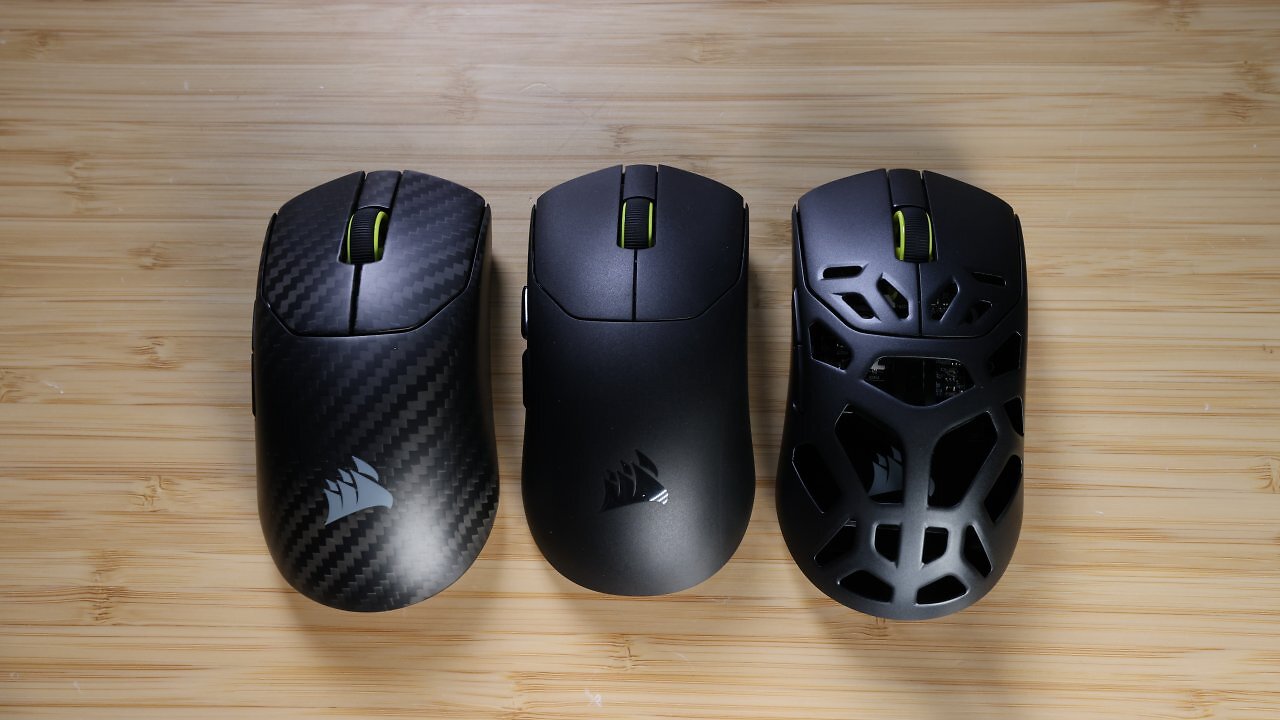 [20/02/2026] Größenvergleich: Die Sabre V2 Pro CF (links) und Sabre V2 Pro MG (rechts) haben die gleiche Größe (38,8 × 64,1 × 122,9 mm; 80&nbsp;cm³). Die ursprüngliche Corsair Sabre V2 Pro Ultralight (Mitte) ist etwas kleiner (38,2 × 62,6 × 119,3&nbsp;mm; 75&nbsp;cm³).&nbsp;