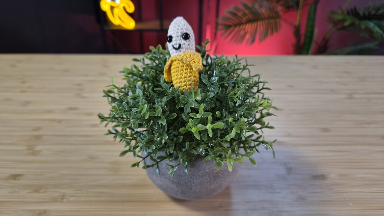 Eine geh&auml;kelte Banane auf einem Holztisch