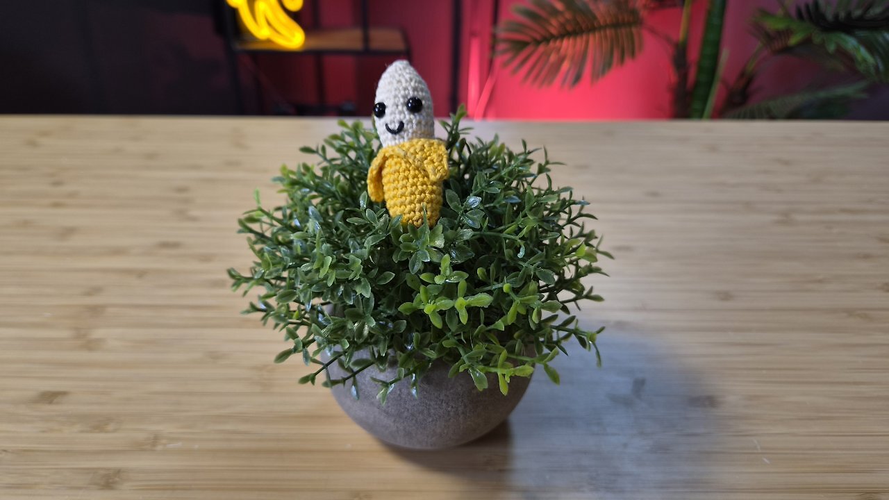 Eine geh&auml;kelte Banane auf einem Holztisch