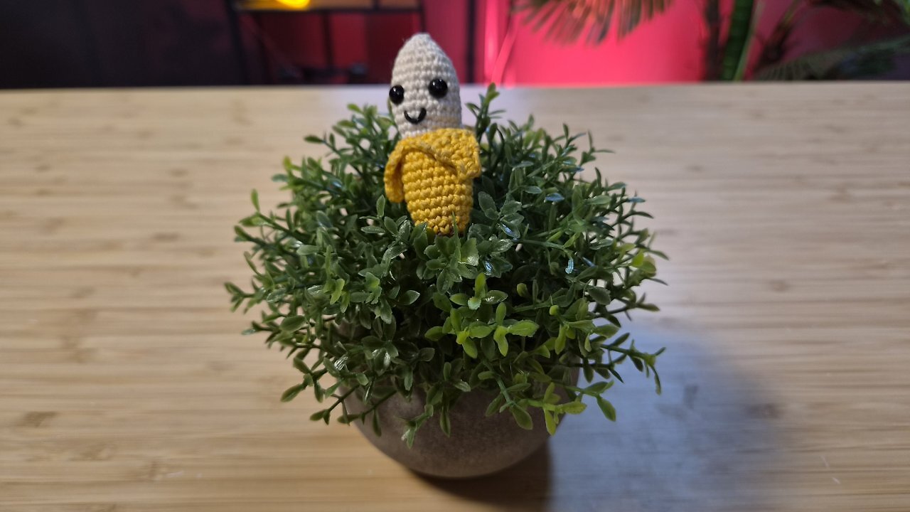 Eine geh&auml;kelte Banane auf einem Holztisch