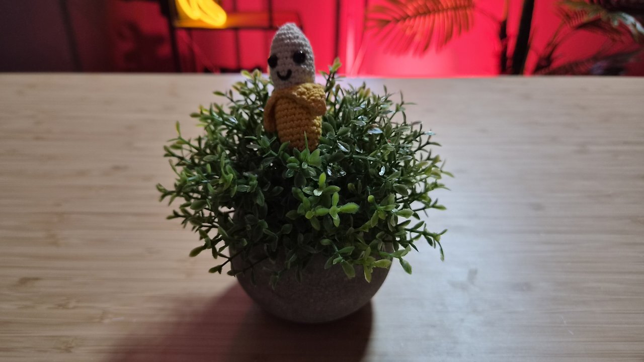 Eine geh&auml;kelte Banane auf einem Holztisch