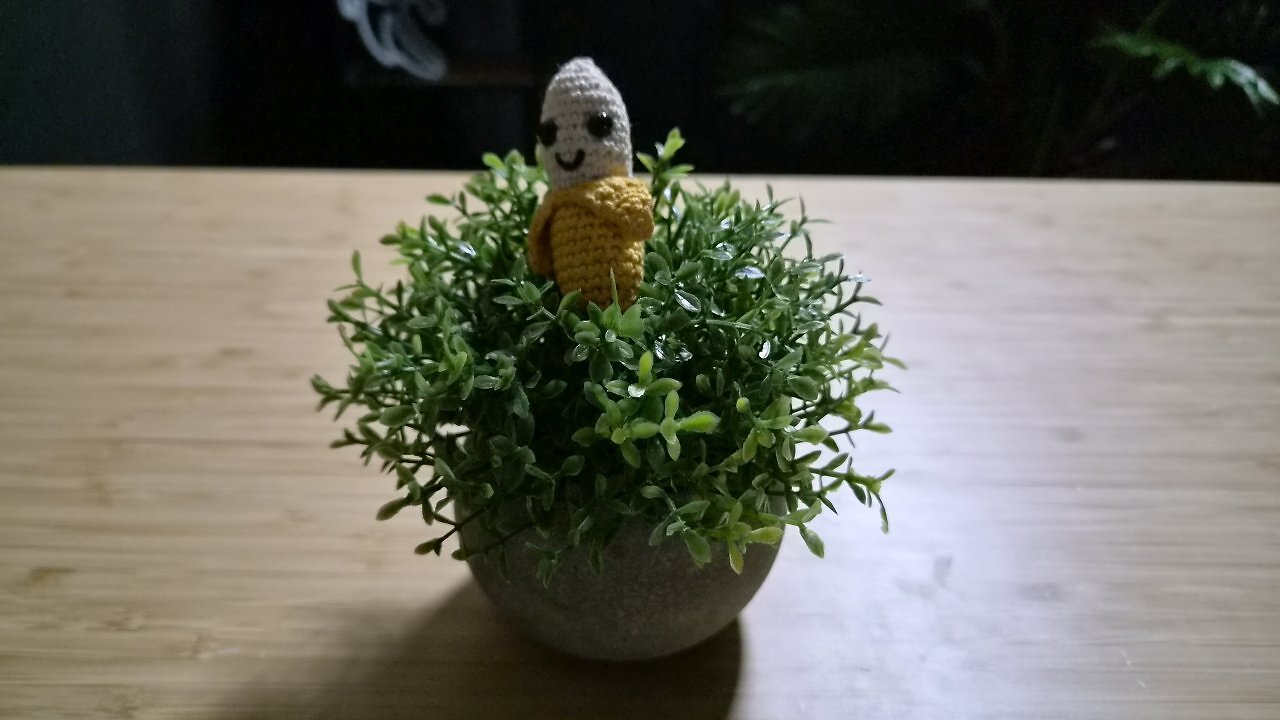 Eine geh&auml;kelte Banane auf einem Holztisch