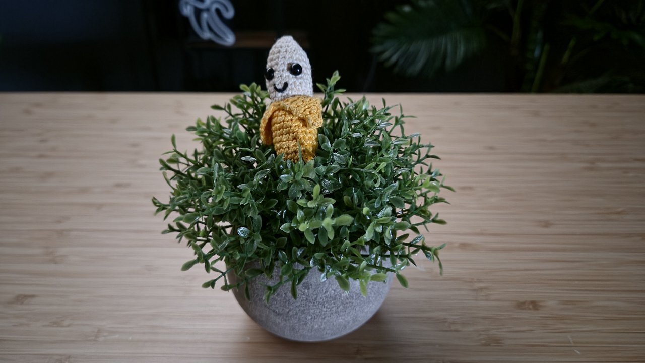 Eine geh&auml;kelte Banane auf einem Holztisch