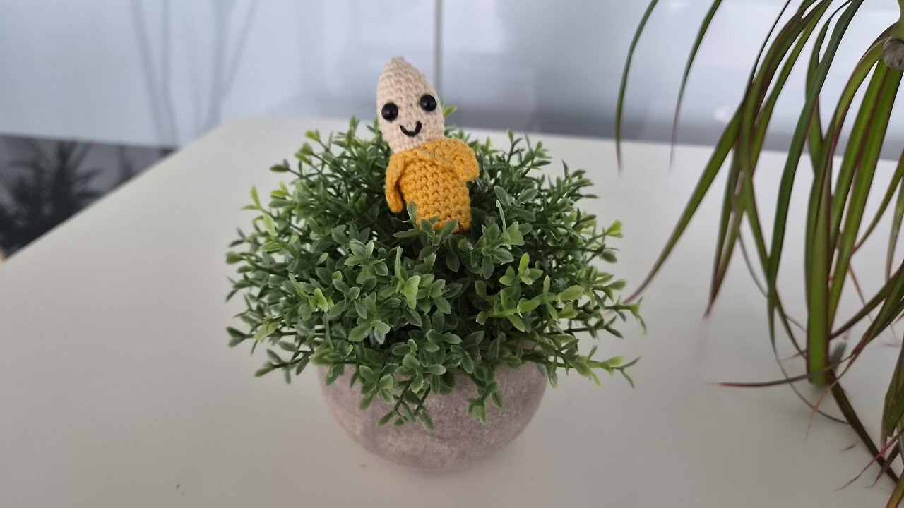 Eine geh&auml;kelte Banane auf einem Holztisch