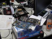 Marcs Arbeitsplatz ist derzeit recht reichlich gefüllt. Er versucht verschiedene Grafikkarten passiv zu kühlen. Die HD-7970-GHz-Edition (mit dem dunklen PCB) soll natürlich nicht passiv auf entsprechenden Temperaturen gehalten werden, sie wartet aber auch brav auf einen Redakteur, der Zeit hat ihr einen neuen Kühler zu verpassen.