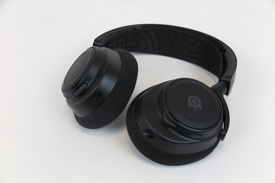 Steelseries Arctis Nova 7 – Die Oberklasse-Version der Nova-Reihe kommt mit Wireless Funk und optionalem Klinkenanschluss. Wieder stehen eine Reihe Features und gegenüber dem Nova 3 zudem einige weitere Funktionen hinzu.Die Treiber sind weiterhin die gleichen wie in Actis Nova 1P und Nova 3, allerdings ist die Abstimmung ein wenig anders. Neben den Anschlüssen unterscheidet sich das Nova 7 indes vor allem äußerlich, denn es nutzt das Design - inklusive Aluminium-Bügel und weiteren Details - des Topmodells Nova Pro und bietet eine nochmals höhere Qualitätsanmutung als die kleineren Geschwister. Auf Extra-Flair, etwa in Form von gebürsteten Seitendeckeln und weitere Akzente des Top-Modells verzichtet das Nova 7 allerdings.